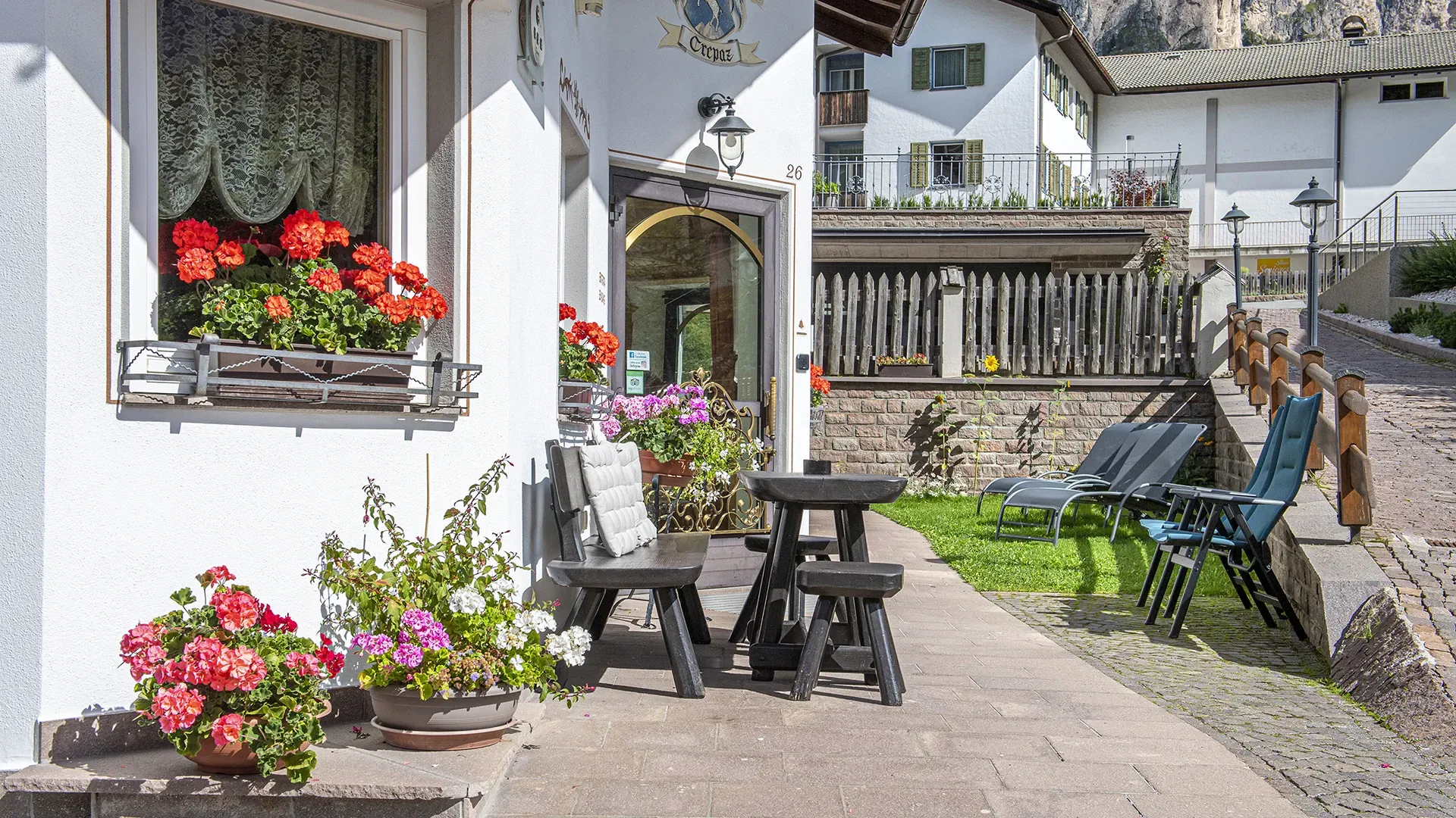 Eingang Garni Crepaz mit Sitzbereich und Blumen